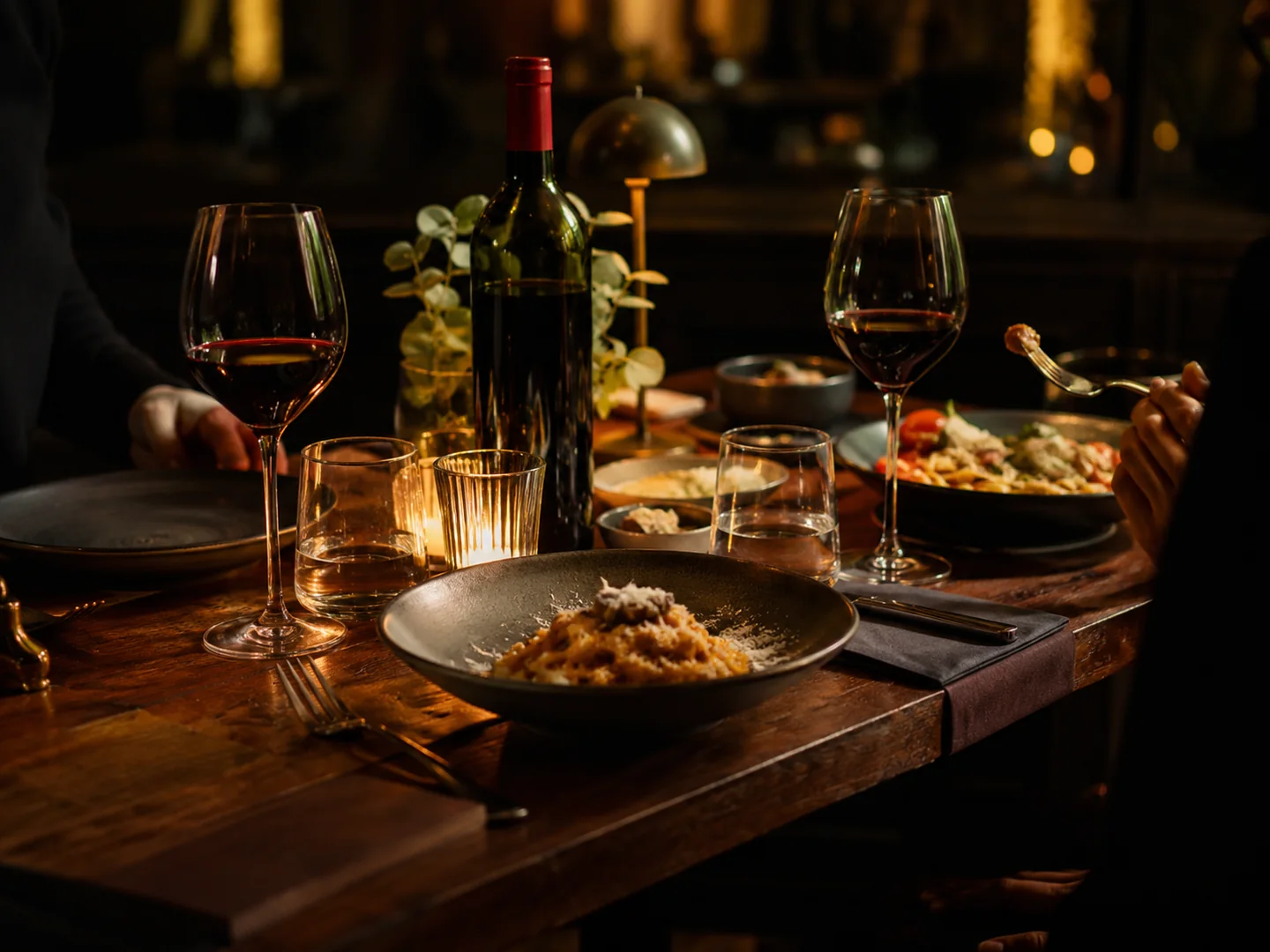 Candlelit Italian dinner table with wine, glassware, and an intimate evening atmosphere
